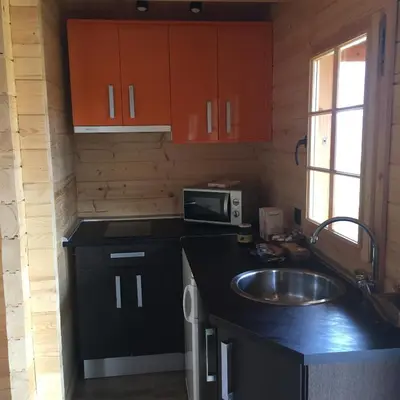 a kitchen with a sink and a microwave at Cabañas Madarsu in Vigo de Sanabria