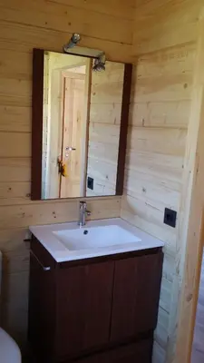 a bathroom with a sink and a mirror at Cabañas Madarsu in Vigo de Sanabria