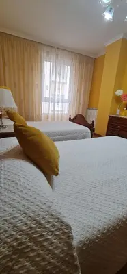 a hotel room with two beds with yellow pillows at Piso Ainoa Playa de Covas in Viveiro
