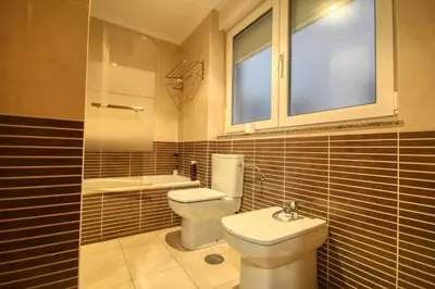 a bathroom with a toilet and a sink and a window at Pension Escalinata in Sarria