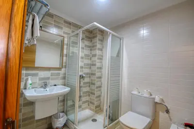 a bathroom with a shower and a toilet and a sink at Pension Escalinata in Sarria