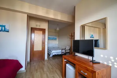 a living room with a flat screen tv on a wooden dresser at Pension Escalinata in Sarria