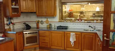 a room with a wooden cabinet and a stone wall at La Casona RibeiraSacra in Moreiras