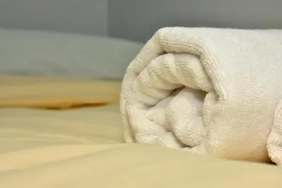 a white towel sitting on top of a bed at O lar Albergue Larouco in Laroco