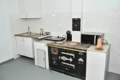 a small white kitchen with a microwave and a stove at O lar Albergue Larouco in Laroco