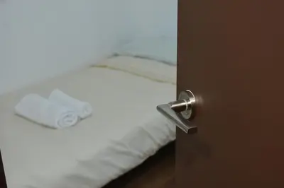 a close up of a bed with white sheets and a door at O lar Albergue Larouco in Laroco