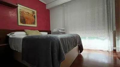 a bedroom with a bed and a red wall at Medorra in Ourense