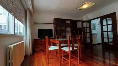 a dining room with a table and chairs and a television at Medorra in Ourense