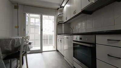 a kitchen with white appliances and a table and a window at Medorra in Ourense
