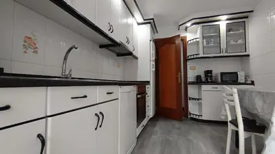 a small kitchen with white cabinets and a sink at Medorra in Ourense