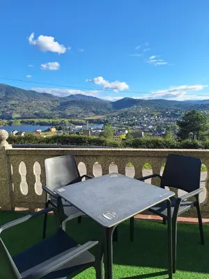 two chairs and a table on a balcony with a view at Hotel Berna in La Rúa
