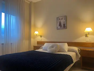 a bedroom with a blue bed with two pillows at Hotel Berna in La Rúa