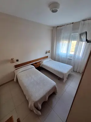 a room with two beds and a window at Hotel Berna in La Rúa