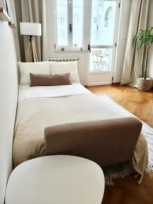 two beds in a room with two windows at Apartamento Ronda Muralla in Lugo