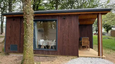 a shed with a table and chairs in a yard at EcoCamp San Román by SuitesNature in Lugo
