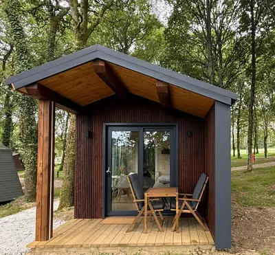 a cabin with a table and chairs on a deck at EcoCamp San Román by SuitesNature in Lugo
