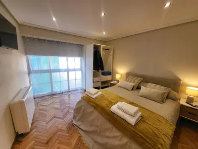 a bedroom with a large bed with two towels on it at Décimo Vera in Ourense