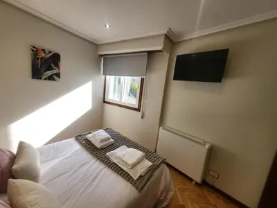 a bedroom with a bed with two towels on it at Décimo Vera in Ourense