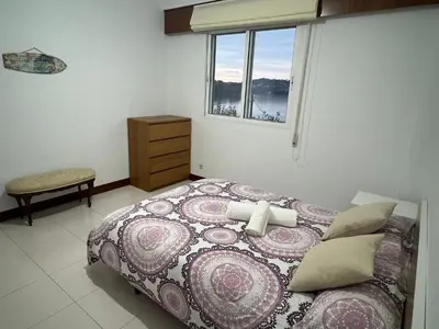 a bedroom with a large bed and a window at Playa Centro Miño in Miño