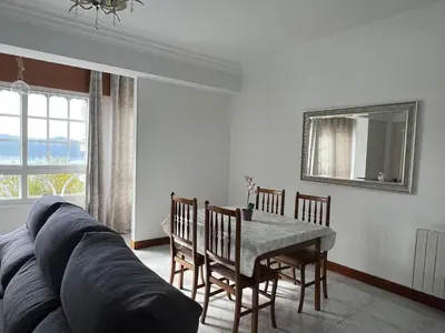 a living room with a table and a couch at Playa Centro Miño in Miño