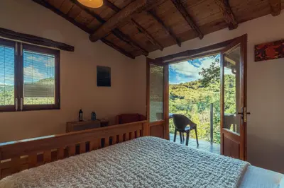 a bedroom with a bed and a large window at Cabo Do Mundo Casa Rural in Chantada