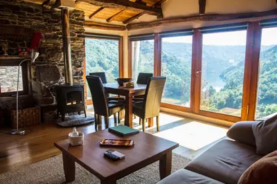 a living room with a table and chairs and a large window at Cabo Do Mundo Casa Rural in Chantada