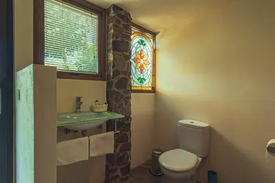 a bathroom with a toilet and a stained glass window at Cabo Do Mundo Casa Rural in Chantada