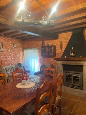 a dining room with a table and a fireplace at Casa Redonda in Ourense