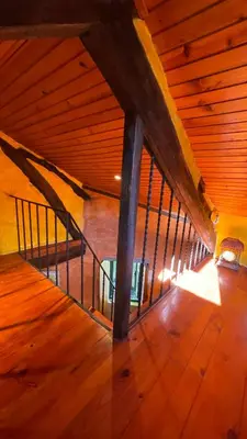 an attic room with a wooden floor and a staircase at Casa Redonda in Ourense