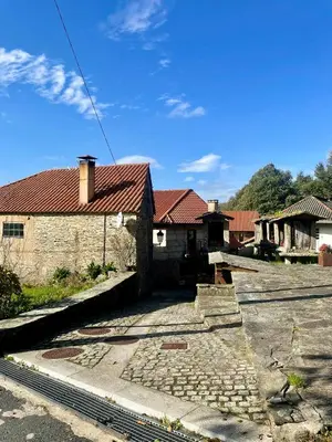 a house with a red roof on a street at Casa Redonda in Ourense