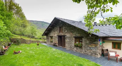 a stone house with a yard in front of it at Apartamentos Rurales Sierra in Palacio de Naviego