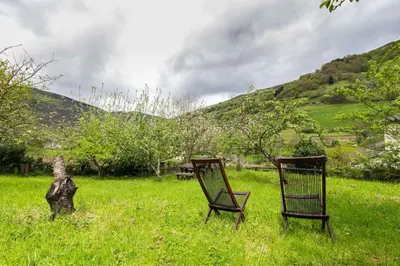 two chairs sitting in the grass in a field at Apartamentos Rurales Sierra in Palacio de Naviego
