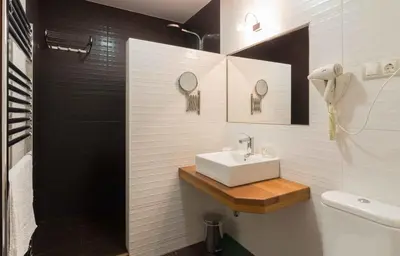 a white bathroom with a sink and a shower at Apartamentos Rurales Sierra in Palacio de Naviego
