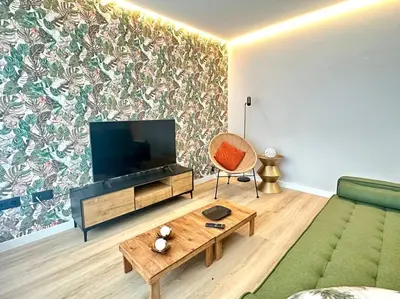 a living room with a green couch and a flat screen tv at Os Potes Bajo in Ares