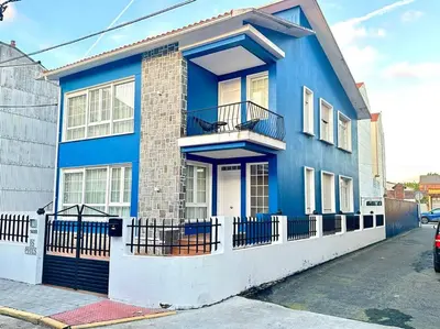 a blue house with a balcony on a street at Os Potes Bajo in Ares