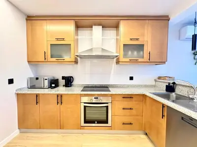 a kitchen with wooden cabinets and a sink at Os Potes Bajo in Ares