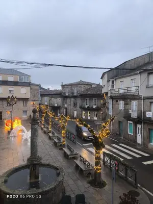 a city with a street with benches and lights at Pension Luscofusco in Puebla de Trives
