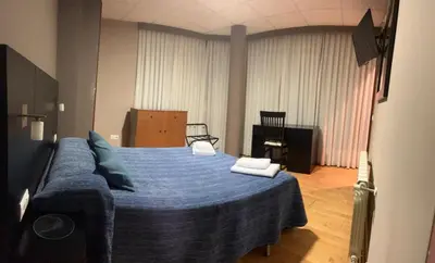 a bedroom with a blue bed with two towels on it at Pension Luscofusco in Puebla de Trives