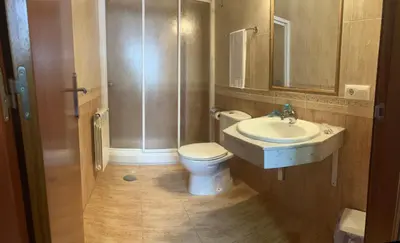 a bathroom with a toilet and a sink and a shower at Pension Luscofusco in Puebla de Trives
