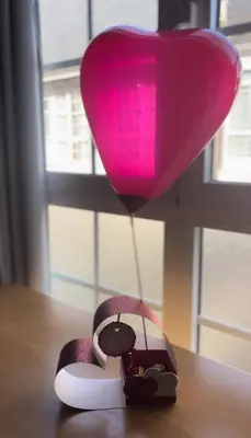 a heart balloon and a watch sitting on a table at Pension Luscofusco in Puebla de Trives