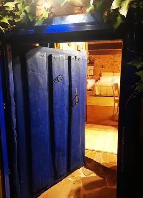 a blue door leading into a room with a bedroom at Arzipreste IV La Casita del Jardín in León