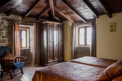 a bedroom with a bed and two windows at Casa Roan y Casa Grande in Lodoso