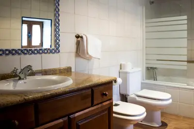 a bathroom with a sink and a toilet and a shower at Casa Roan y Casa Grande in Lodoso