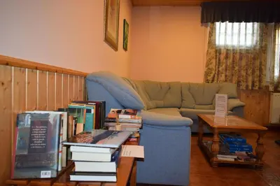 a living room with a couch and a table with books at Hotel Restaurante Las Camelias in Jarrio