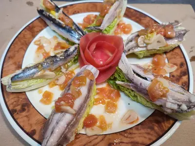 a plate of food with fish and vegetables on it at Hotel Restaurante Las Camelias in Jarrio
