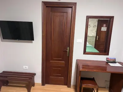 a room with a television and a wooden door at Hotel Celta Galaico in Viveiro