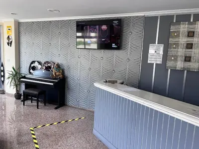 a room with a piano and a television on a wall at Hotel Celta Galaico in Viveiro