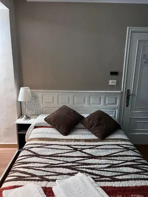 a bedroom with a bed with two pillows on it at Hotel Celta Galaico in Viveiro