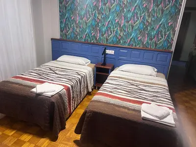 two beds in a room with a painting on the wall at Hotel Celta Galaico in Viveiro