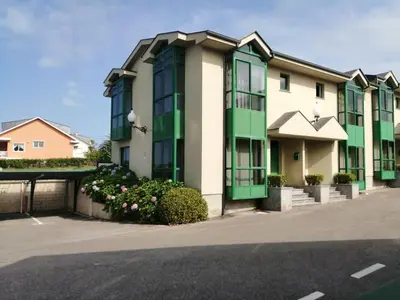 a building with green windows on a street at Urbanización Mar Cantábrico in Barreiros